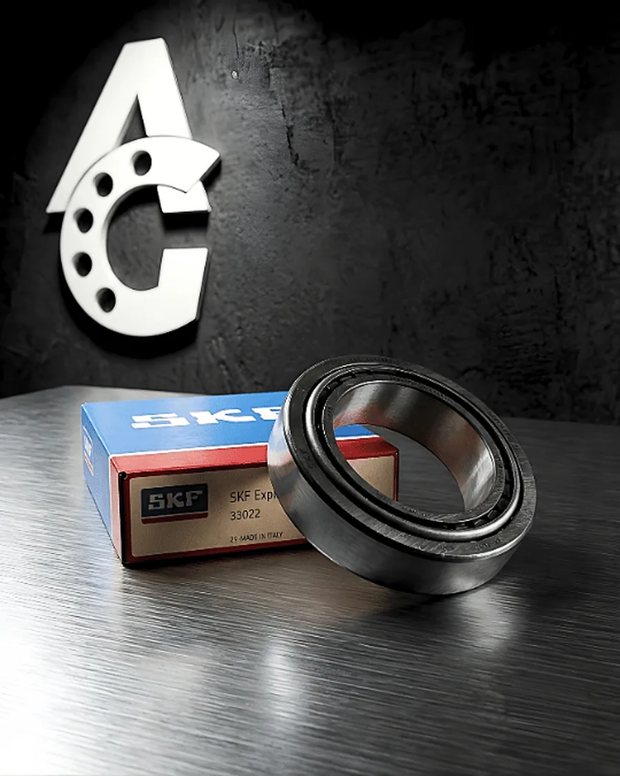 Rodamiento de rodillos cónicos SKF Explorer 33022 apoyado sobre su caja, sobre una superficie de acero